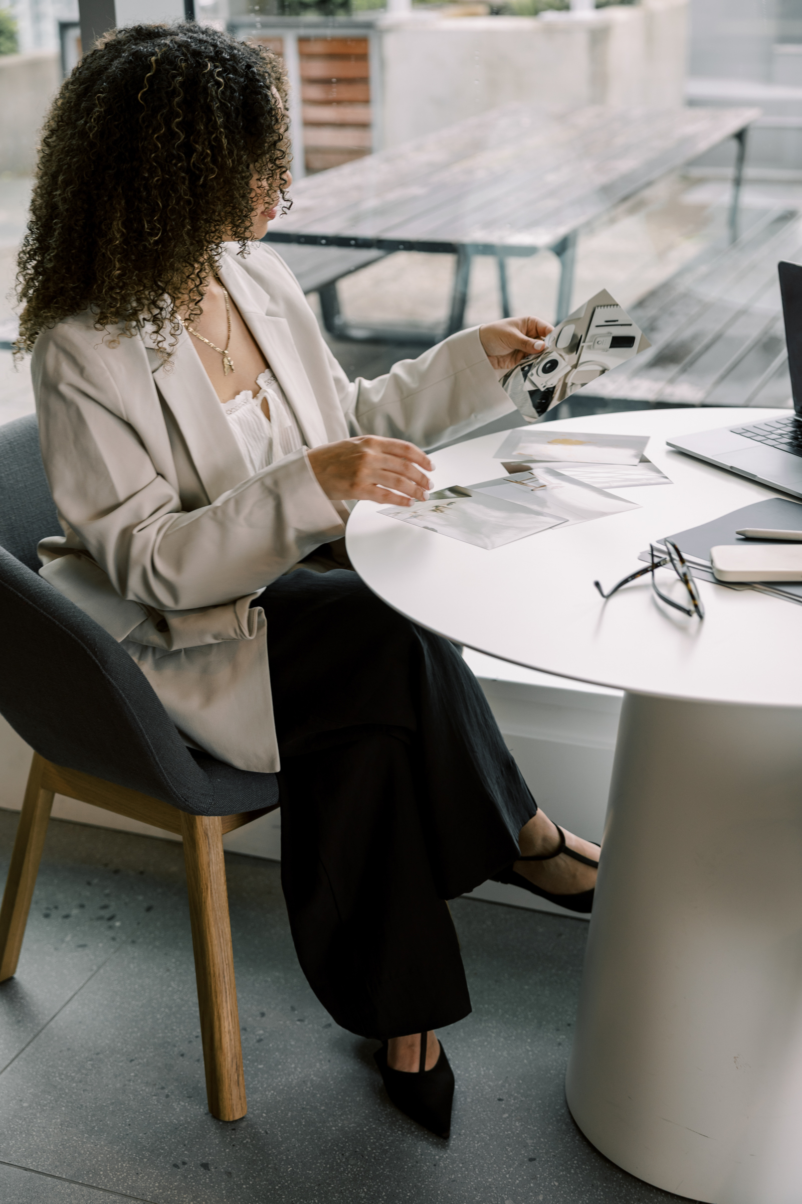 Woman of color business owner reviewing automated CRM workflow on laptop in branded, professional home office setup.