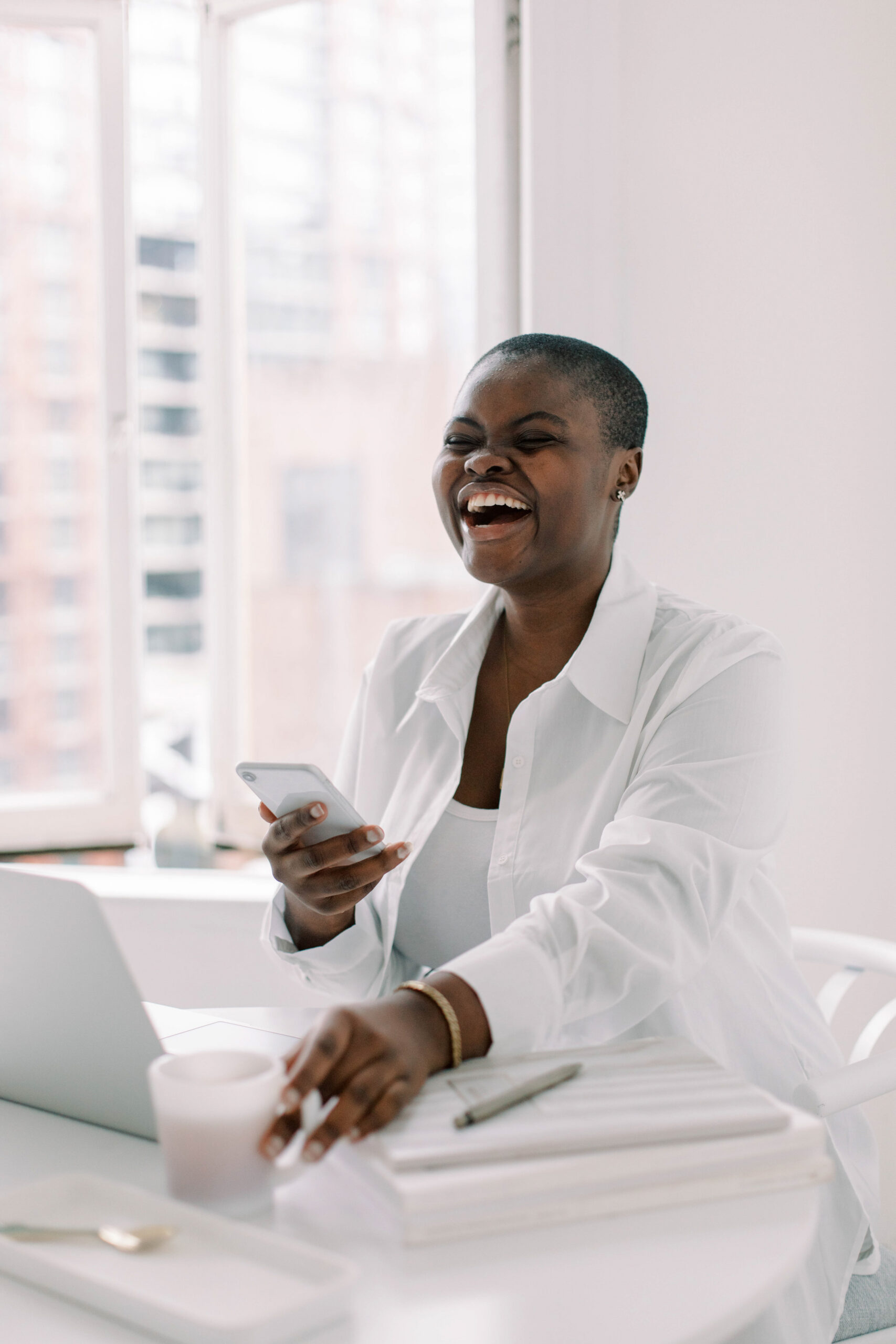 Black woman business owner standing confidently in front of a clean, elevated branded workspace, looking directly at the camera.