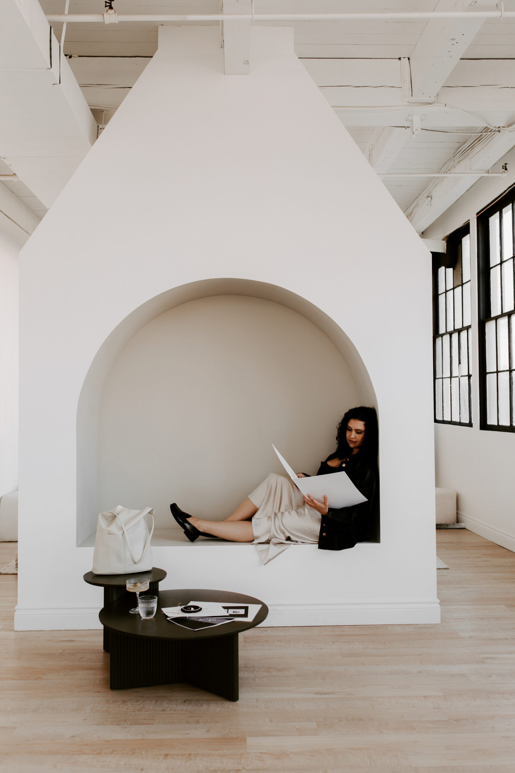 Woman of color service business owner reviewing website layout and design strategy on laptop at a clean, minimal desk.