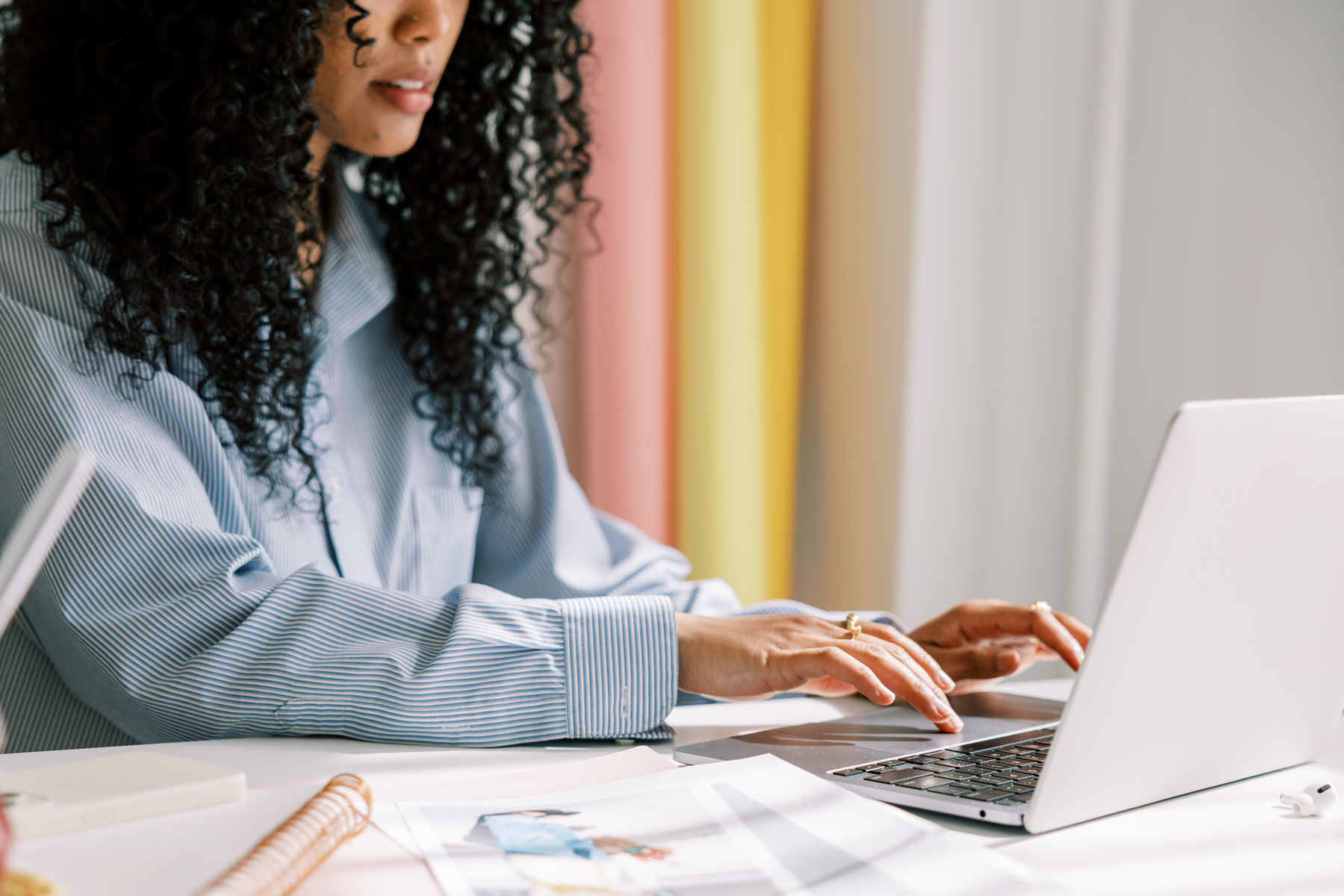 Established woman of color business owner reviewing brand materials and strategy documents at a clean, professional desk.